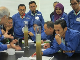 凝集剤による固形物の沈殿の状況を真剣に見つめる研修生