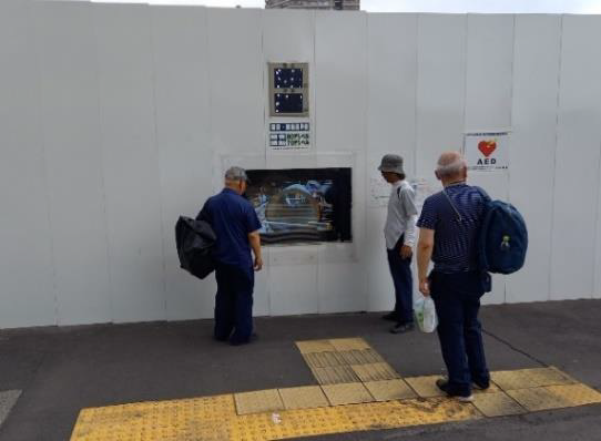 写真：デジタルサイネージ（観覧する様子）